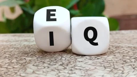 Turns a dice and changes the expression IQ Intelligence Quotient to EQ Emotio Stock Photos