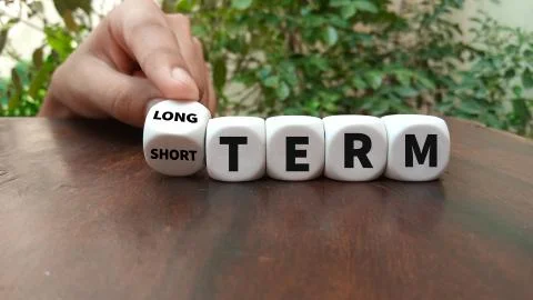 Turns a dice and changes the expression SHORT TERM to LONG TERM or vice versa Stock Photos