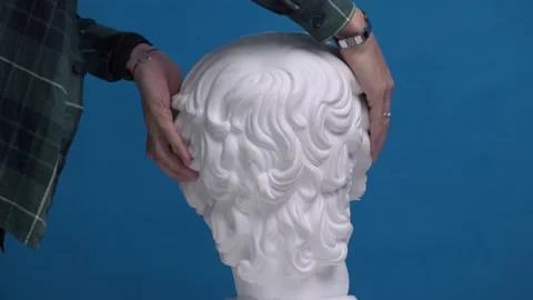 Turns his face to the camera of plaster bust wearingnew medical mask on his face Stock Footage 162543226