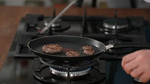 Turns meatballs while cooking Stock Footage 183515731
