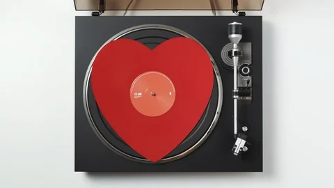 Turntable. Loop. Top view of with a rotate red heart-shaped vinyl record Stock Footage 100879349