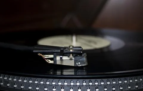 Turntable playing vinyl close up with needle on the record. Stock Photos