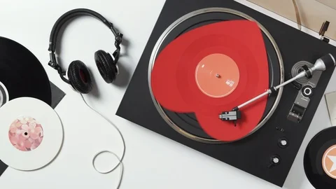 Turntable. Top view of a music player a spinning red heart-shaped vinyl record Stock Footage 100879684