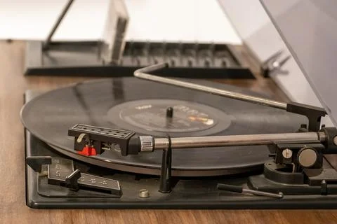 Turntable vinyl record player with vinyl records on a wooden table . black .. Stock Photos