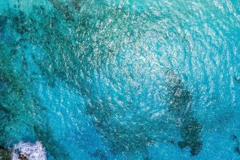 Turqoise blue sea texture with waves and foam. 库存照片