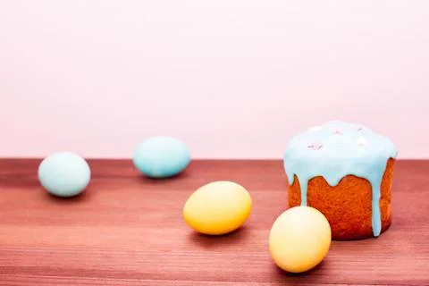 Turquoise and yellow Easter eggs on a pink background with Easter cake in glaze Stock Photos