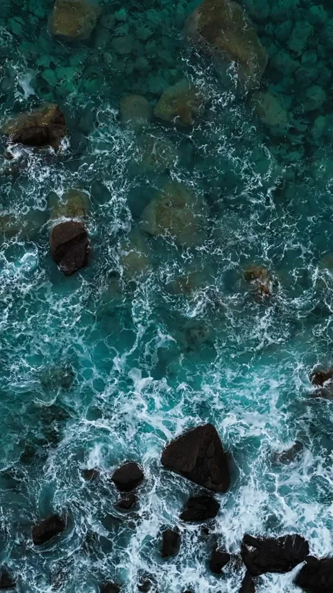 Turquoise Atlantic water with wave foam moving around rocks. Aerial view Stock Footage 340078730