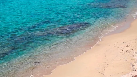 Turquoise azure sea waves breaking gently on a sandy beach Stock Footage 82807982