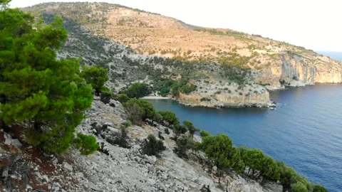 Turquoise bay with a sandy beach below steep cliffs, Thassos reveal Stock Footage 347170445