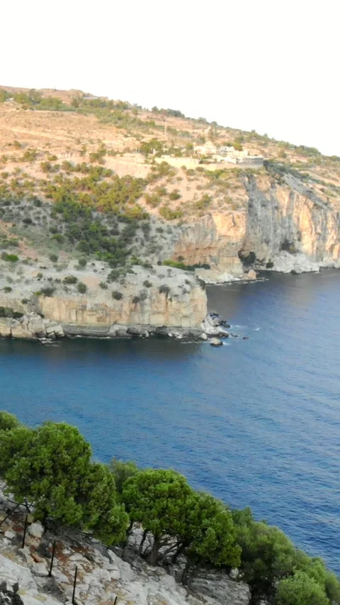 Turquoise bay with sandy beach below cliffs, Thassos, vertical Stock Footage 347178039