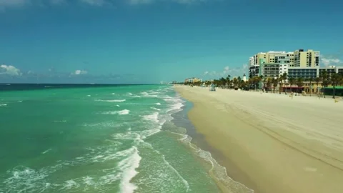 Turquoise beach waves, oceanfront cityscape view, cinematic beach drone Stock Footage 309537833