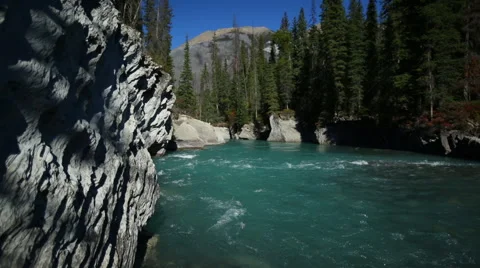 TURQUOISE BLUE RIVER FLOWS BY WHITE GRANITE ROCK Stock Footage 59073267