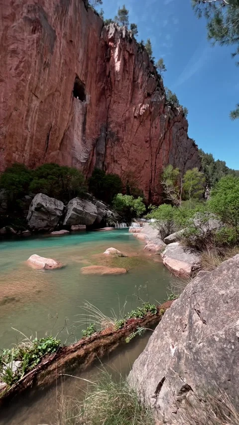Turquoise canyon pool below red rocky cliffs Stock Footage 334850905