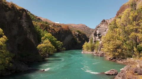 Turquoise current winding between tree lined cliffs in Kawarau gorge 스톡 동영상 348112377