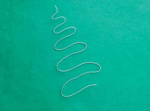 On the turquoise felt is a silver Herringbone made of soft wire. Christmas an Stock Photos