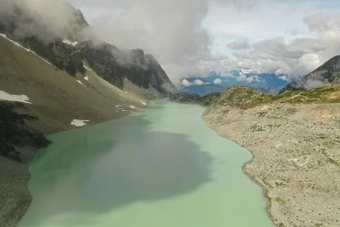 Turquoise glacier lake in the clouds Stock Photos