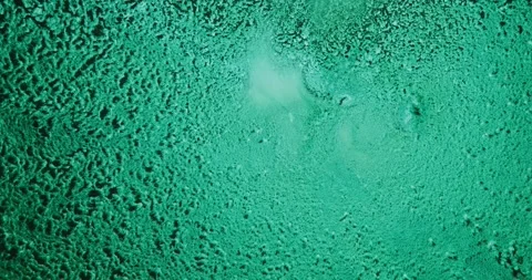 Turquoise Granular Fluid Texture With Central Diffusion Pattern and Subtle Stock Footage 306934617