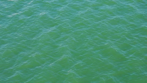 Turquoise ocean water with gentle surface ripples glistening Stock Footage 345936566