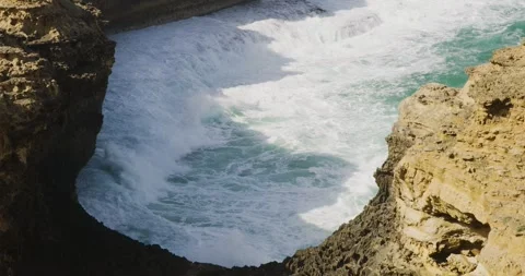 Turquoise Ocean Waves Exploding on Ancient Rock Formations 動画素材 330277160