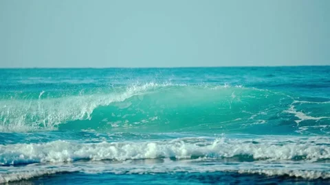Turquoise ocean waves with foamy whitecaps breaking and rolling on a sunny day Stock Footage 344240793
