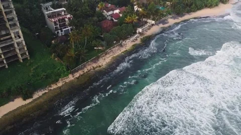 Turquoise ocean waves forcefully breaking against rocky coastline Stock Footage 346569940