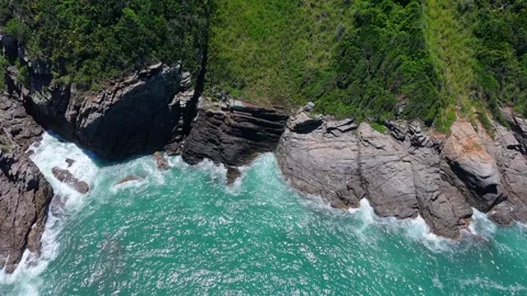 Turquoise ocean waves hitting rocky cliffs in Buzios, Rio de Janeiro, Brazil Stock Footage 332450127