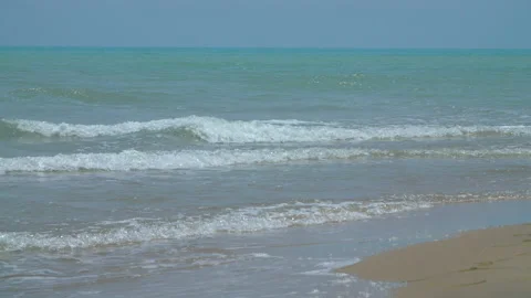 Turquoise ocean waves roll in on the peaceful shore Stock Footage 140168847