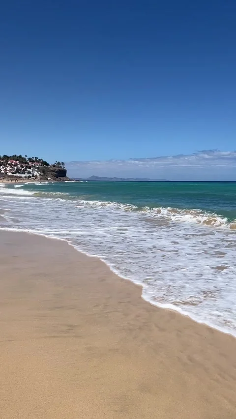 Turquoise ocean waves sandy beach Morro Jable cliff Fuerteventura HD vertical Stock-Footage 342027768