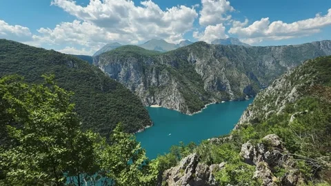Turquoise Piva Lake winds between steep rocky mountains and green forest in Stock Footage 344901554