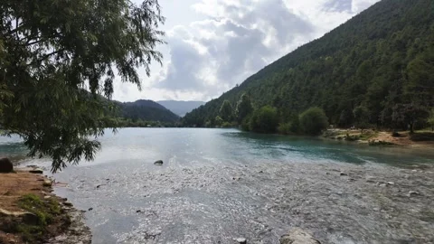 Turquoise River in Mountain Valley with Forested Banks and People Stock Footage 340131456