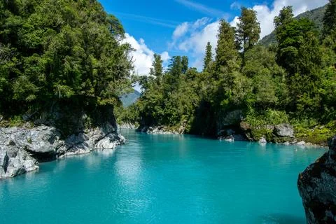 Turquoise River Surrounded by Lush Forests Stock Photos