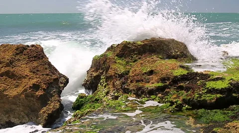 Turquoise rolling wave slamming on the rocks . Stock Footage 49581395