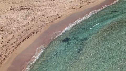 Turquoise sea that breaks on the beach with red reflections Stock Footage 128932982