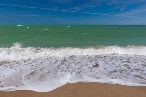 Turquoise Sea Waves Breaking on Sandy Beach Under Blue Sky Photos