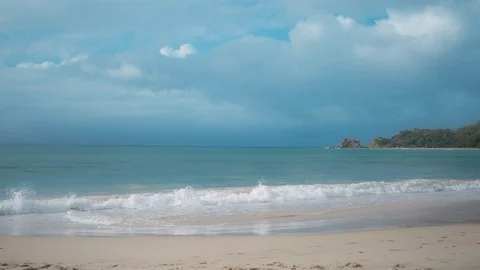 Turquoise sea waves hitting the beach on a sunny day Vídeos de archivo 94884857