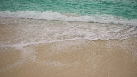 Turquoise sea waves roll on the sandy beach, slow motion Stock Footage 232172094