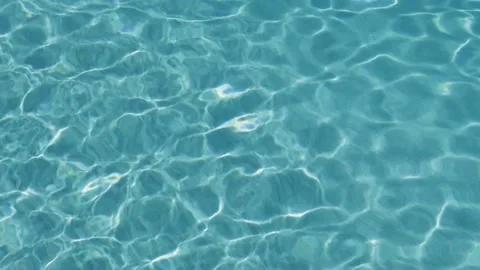 Turquoise surface of sunlit swimming pool.  Light ripples reflection refraction Stock Footage 185553148