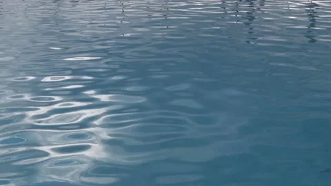 Turquoise surface of sunlit swimming pool.  Light ripples reflection refraction Stock Footage 185553149