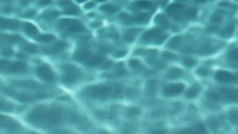 Turquoise surface of sunlit swimming pool.  Light ripples reflection refraction Stock Footage 266533872