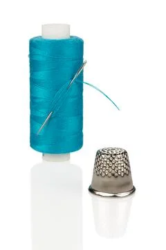 Turquoise Thread Spool with Needle and Silver Thimble Close-up Isolated Stock Photos