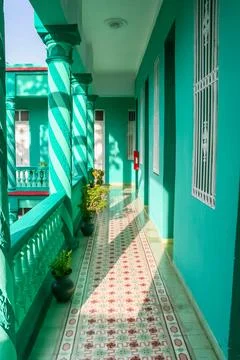 Turquoise veranda features patterned floor tiles and spiral columns in Camagu Stock Photos
