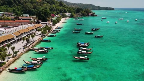 Turquoise water coast of phi phi island in Thailand, with traditional longtail Stock Footage 310874823