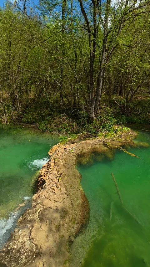 Turquoise water flows through mossy stones. Vertical POV, Balkan, Eastern Europe Видео 333700541