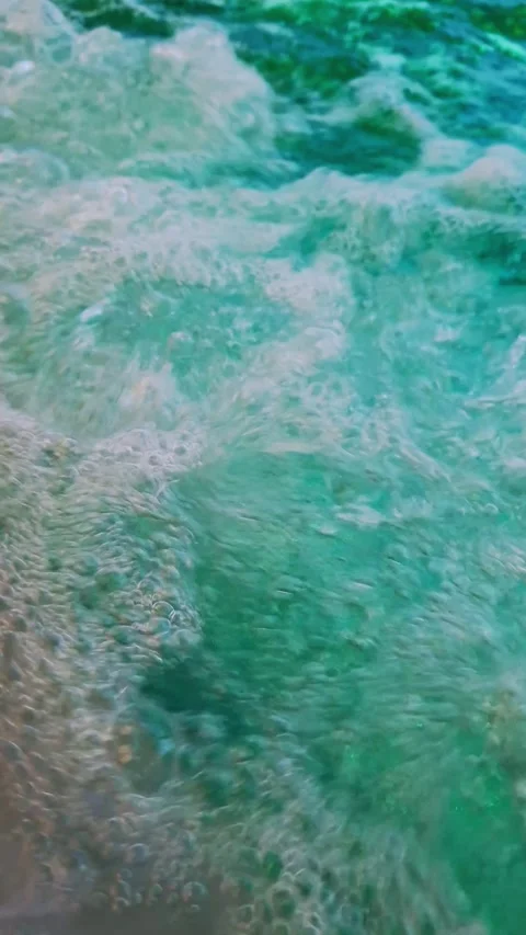 Turquoise Water Surface with Bubbles, Gentle Waves, and Flowing Current Stock Footage 338995028