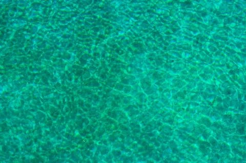 Turquoise water surface with sun reflection..blurred abstract image of a wate Stock Photos