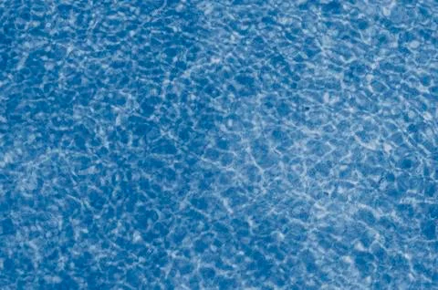 Turquoise water surface with sun reflection..blurred abstract image of a wate Stock Photos