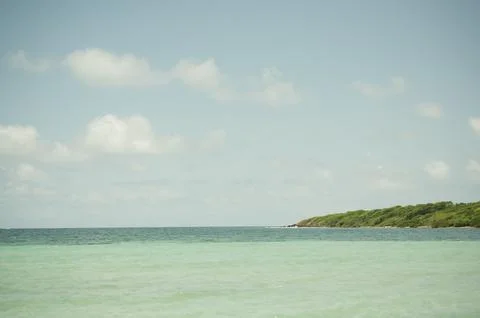 Turquoise waters and distant green coastline at Playa La Chiva Stock-Fotos
