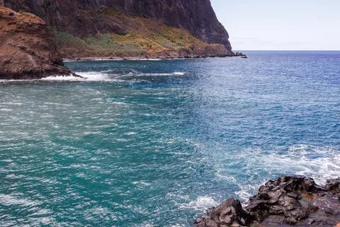 Turquoise waters of the Atlantic Ocean between high cliffs, cloudy sky and .. Stock Photos