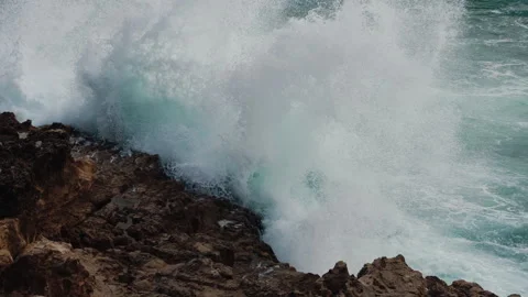 Turquoise Waters Clash With Rocks, Dynamic Sea Waves Crash Onto Rugged Shoreline Stock Footage 327607938