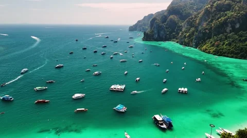 Turquoise waters phi phi island, colorful boats anchoring near white sandy Stock Footage 310910323